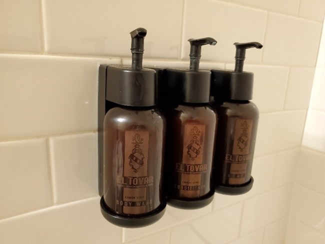 three lotion dispensers on a wall