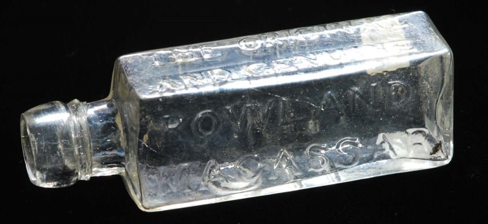Macassar oil bottle Colorless glass bottle, square shaped, with raised lettering
