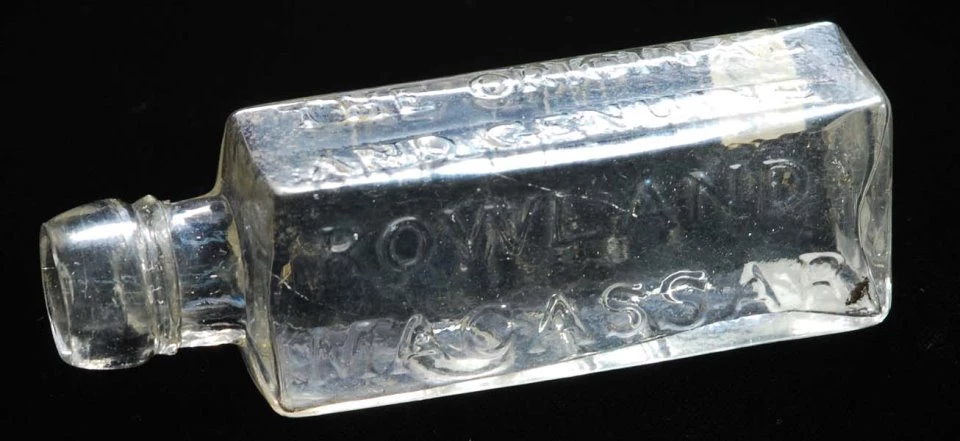 Macassar oil bottle Colorless glass bottle, square shaped, with raised lettering