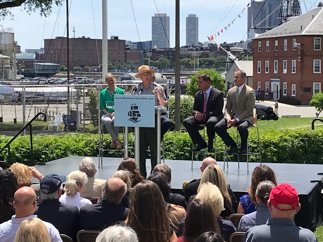 A man in a National Park Service uniform speaks at a podium