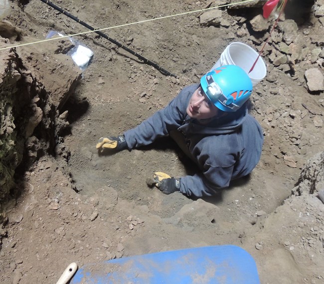 scientist digging at fossil site