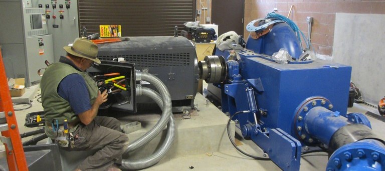 An engineer calibrates the electrical output from the micro-hydro generator.