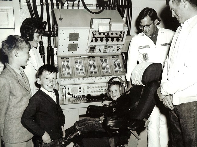Family visits a control center, 1960s A family poses in front of a missile combat console in an underground control center
