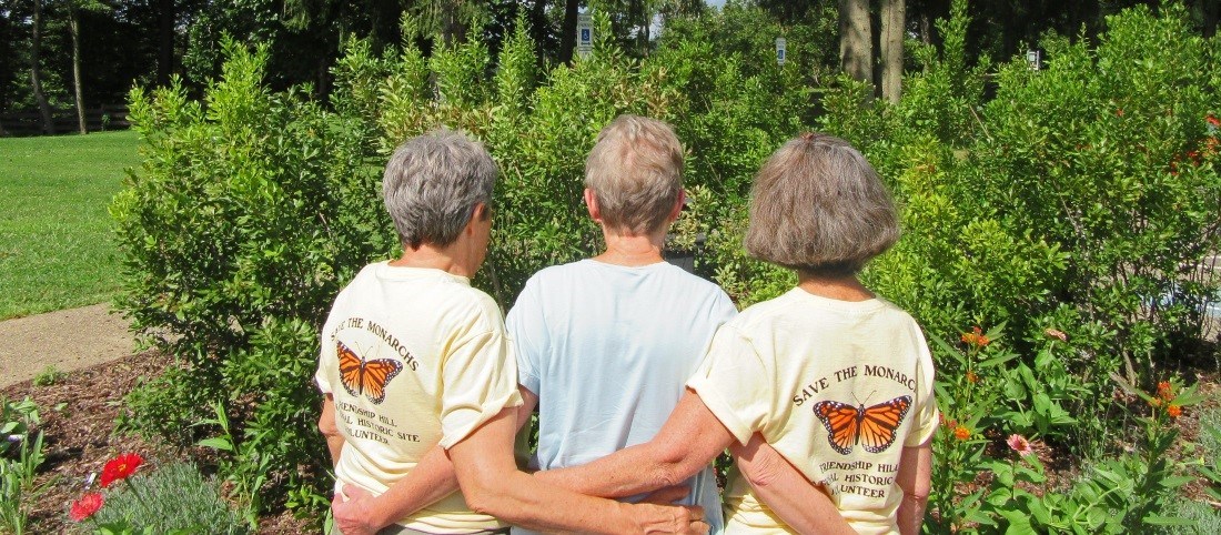 Three ladies wearing shirts that say "Save the Monarchs!" stand with their backs facing the camera Three ladies wearing shirts that say "Save the Monarchs!" stand with their backs facing the camera
