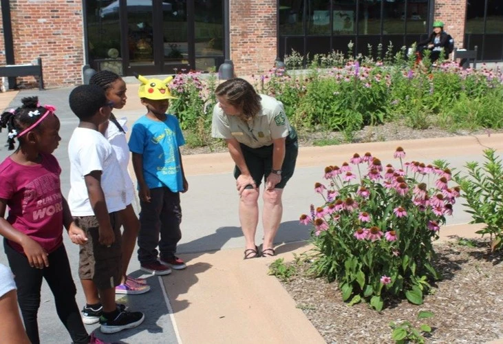 A employee of Motorcities NHA speaking to children about pollinators A employee of Motorcities NHA speaking to children about pollinators