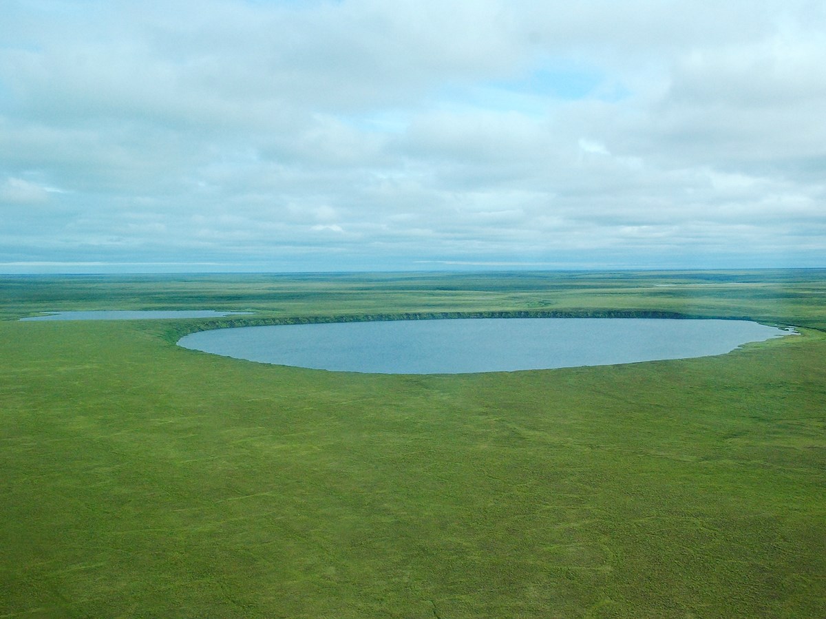Two large lakes on a flat verdant tundra.