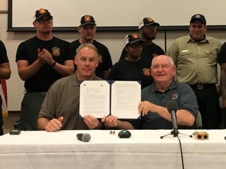 Secretary of Agriculture Sonny Perdue and Secretary of the Interior Ryan Zinke hold up their joint memo on interagency collaboration and cooperation after signing in May 2017 at the National Interagency Fire Center in Boise, Idaho. Photo courtesy of USDA.
