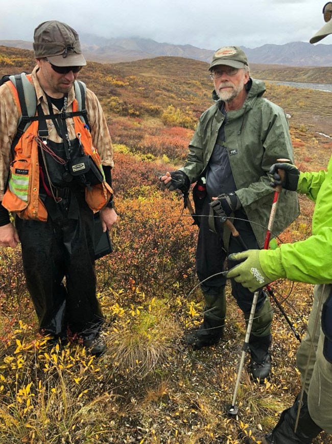 a park ranger and two people in a field