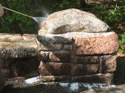 a pressure washer sprays a stone bridge