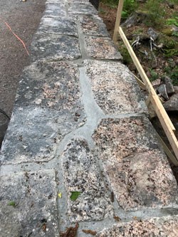 looking down on a stone wall with new mortar in between stones