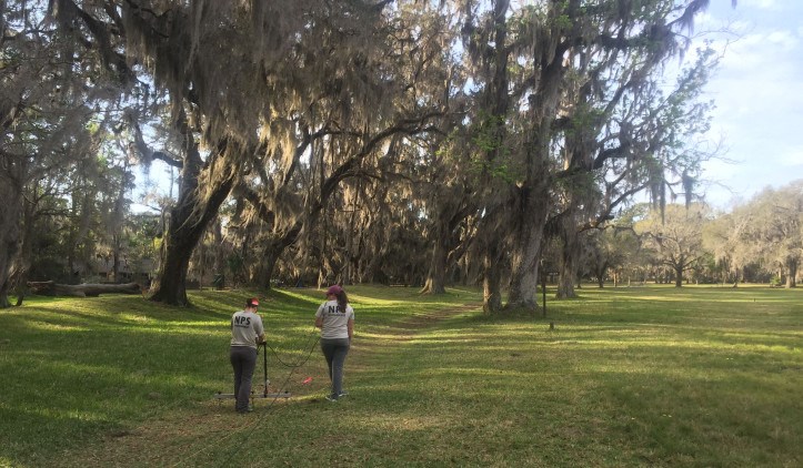 SEAC archeologists Jessica Fry and Amelia Jansen operating the resistivity unit.