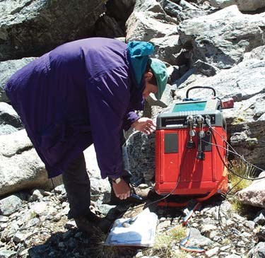 Geologist uses a large square radar device on along the ground to determine permafrost thickness.