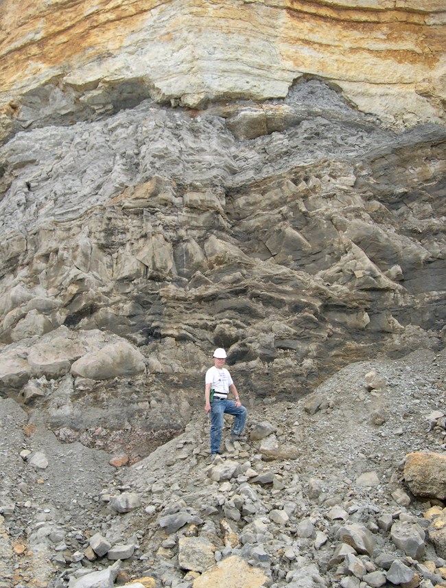 scientist standing at rock outcrop