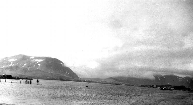 Black and white photo of a bay with mountains in the background