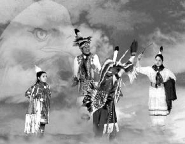 4 people in native dress dance among clouds. Faded eagle head looks over them.