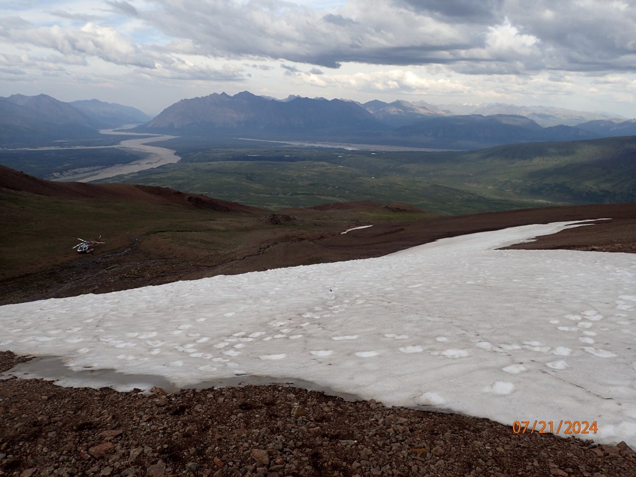 A snow patch along a rocky mountain slope, in a photo dated 07/21/2024.