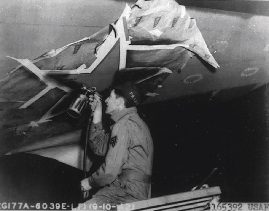 Man painting star on the side of an airplane.