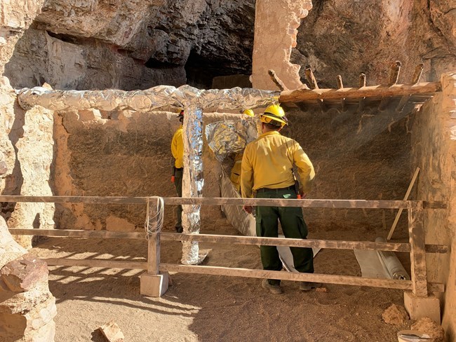 Cliff dwelling roof beam wrapped by crew Cliff dwelling roof beam wrapped by crew