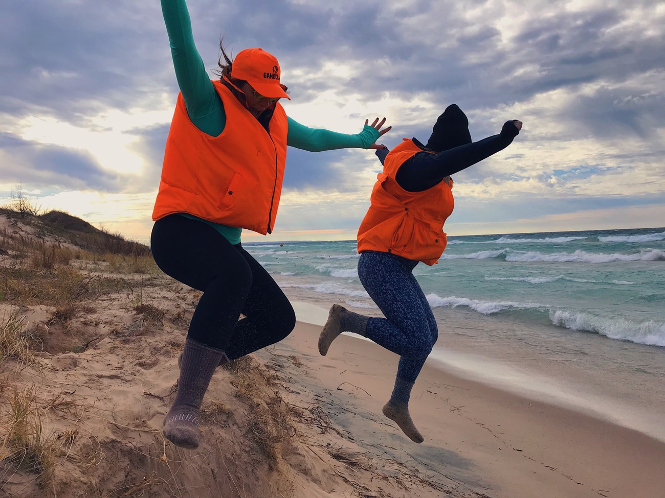 two people jump toward lakeshore