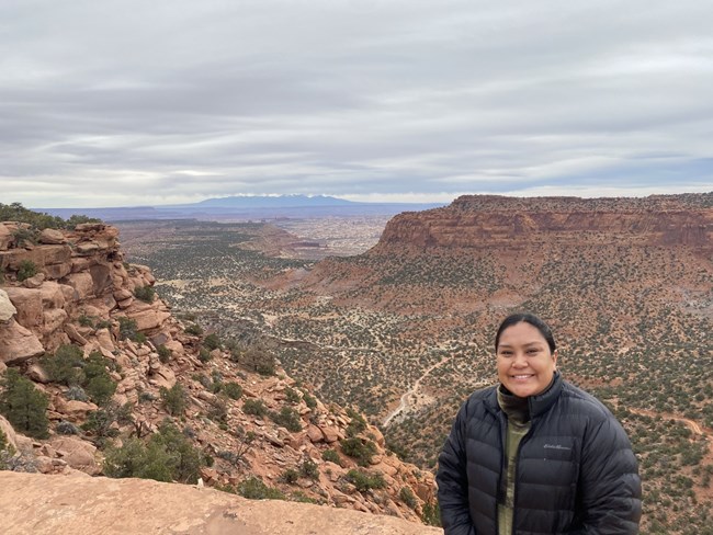 A person standing at a scenic canyon overlook.