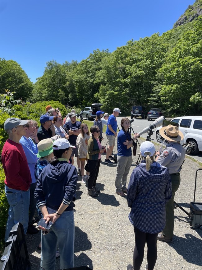 Digital Media Interpretation Kit Group of people surround a ranger with a large camera and display screen