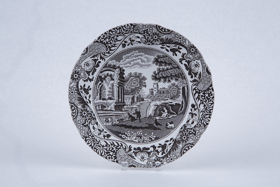 A small plate with a rural scene on it in dark brown.