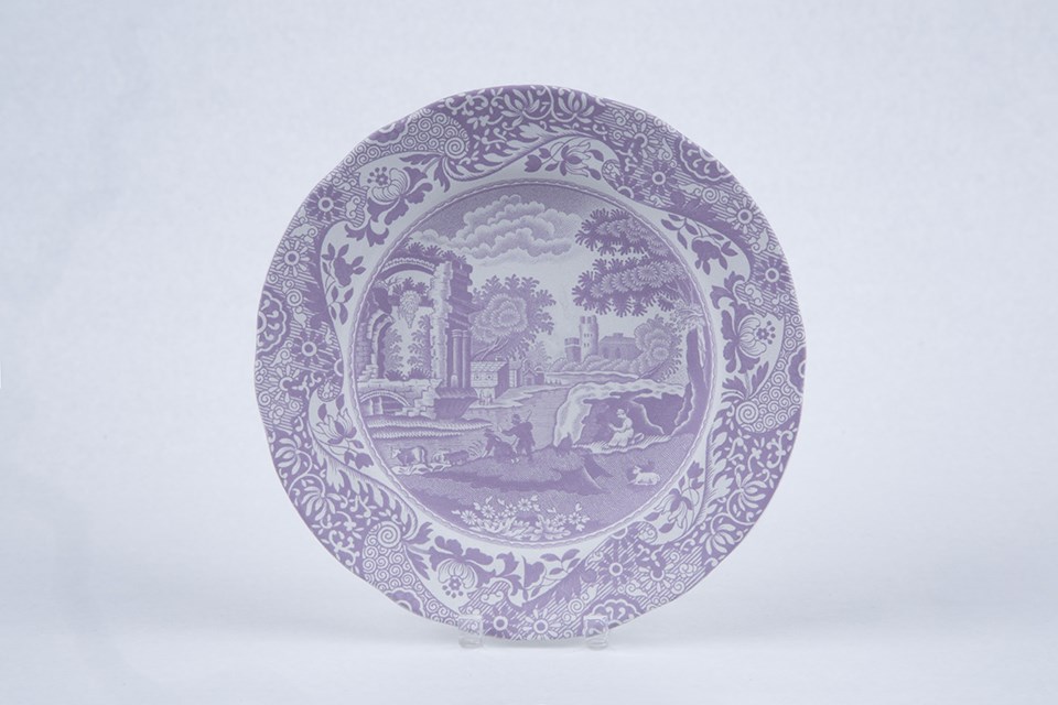 A small plate with a rural scene on it. The color of the print is now light purple.