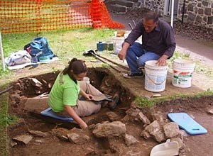 Archeologist and volunteer excavate.