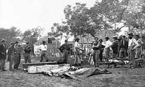 Men preparing battlefield dead for burial.