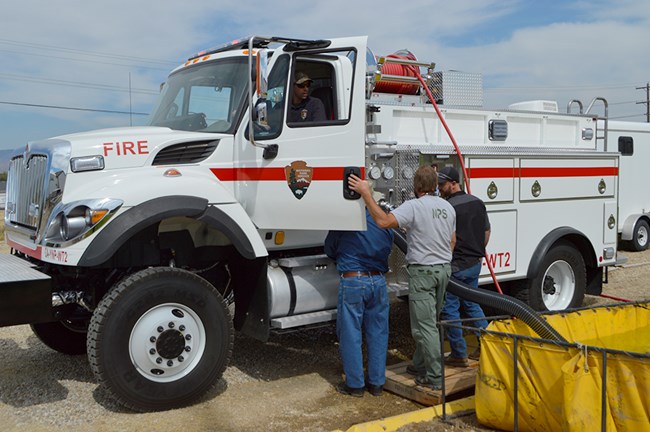 Men look in the door of a large fire vehicle