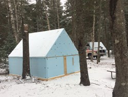 Tent where masons work blue tent in snowy campground with vehicle in background