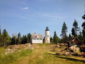 Front view of lighthouse and keeper’s house after treatment. Vegetation and trees have been cleared from the area surrounding the buildings.