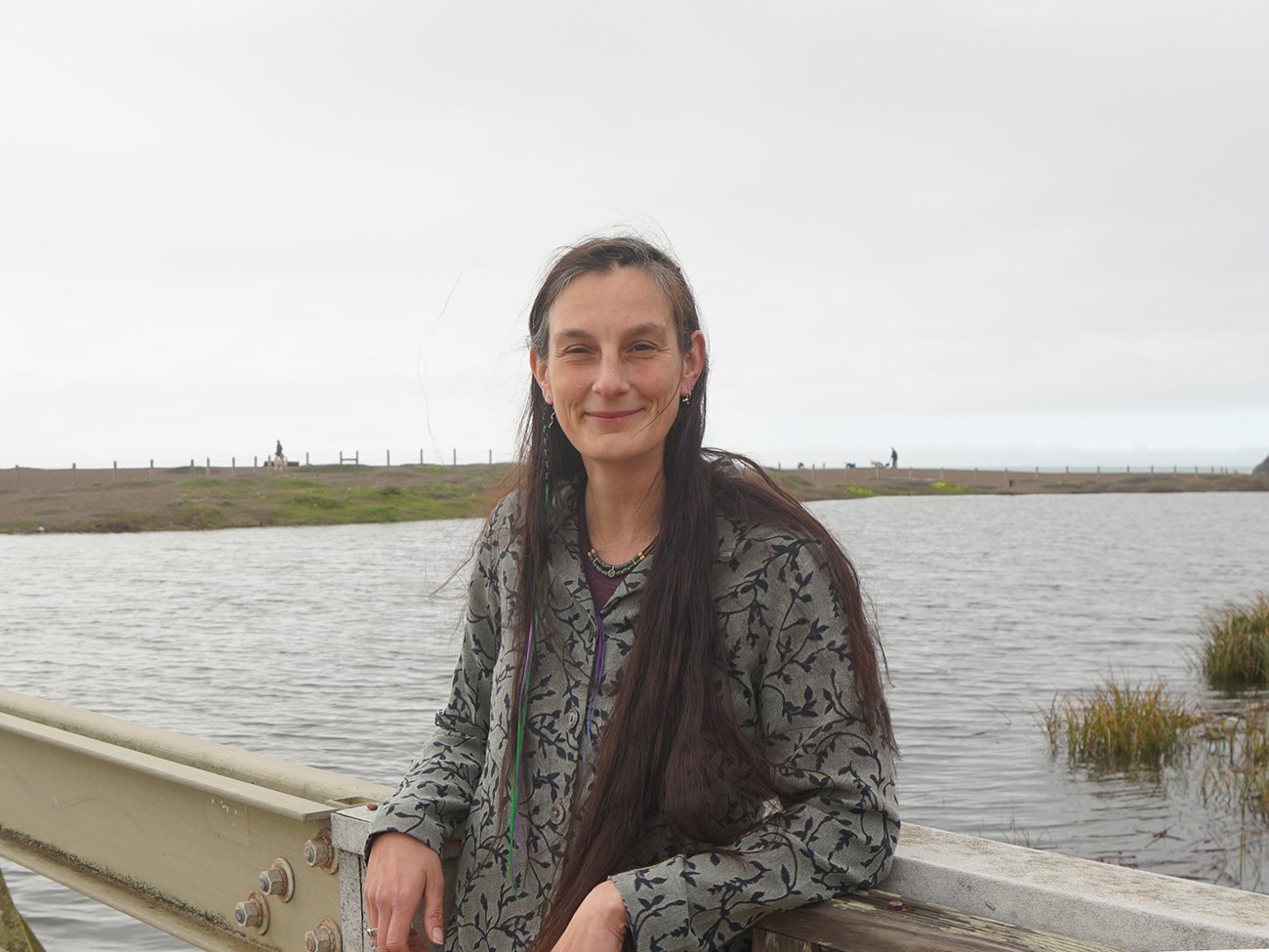 Lizzy in the Marin Headlands Portrait of Lizzy Edson smiling next to Rodeo Lagoon