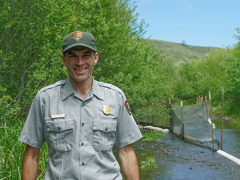 xxiDSC00758 Fisheries biologist Michael Reichmuth poses by creek with smolt trap.
