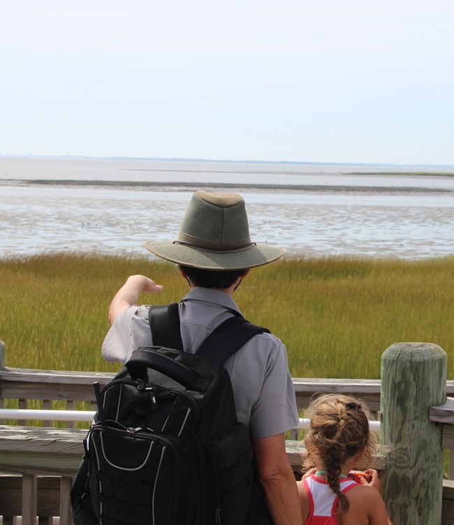 Ranger and student look over the salt marsh.