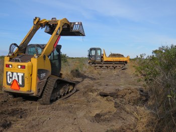 Heavy equipment on the salt marsh being used to remove an abandoned asphalt roadway on Assateague.
