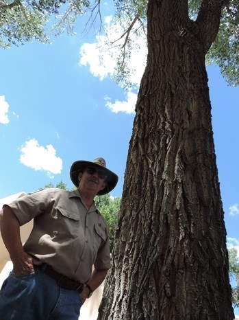 Aztec Ruins volunteer in front of tree Aztec Ruins volunteer in front of tree