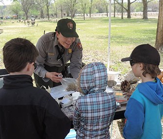 Park ranger and kids looking at seeds. Park ranger and kids looking at seeds.