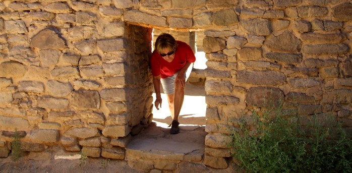 A visitor ducking through a low original doorway