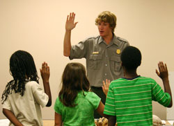Ranger initiating the Junior Ranger Pledge to a group of children