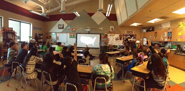 A park ranger teaching about fossils in a classroom.