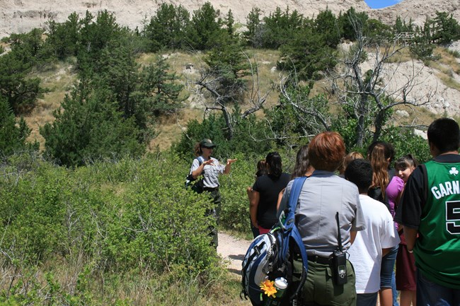 A park ranger leading a group of students through the park.