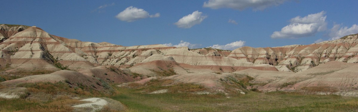 layered badlands buttes reach into a cloudy sky above