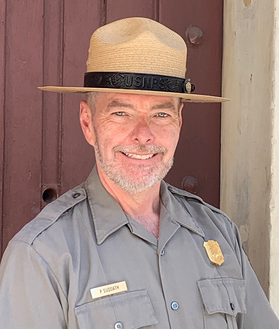 A smiling man in a park ranger hat