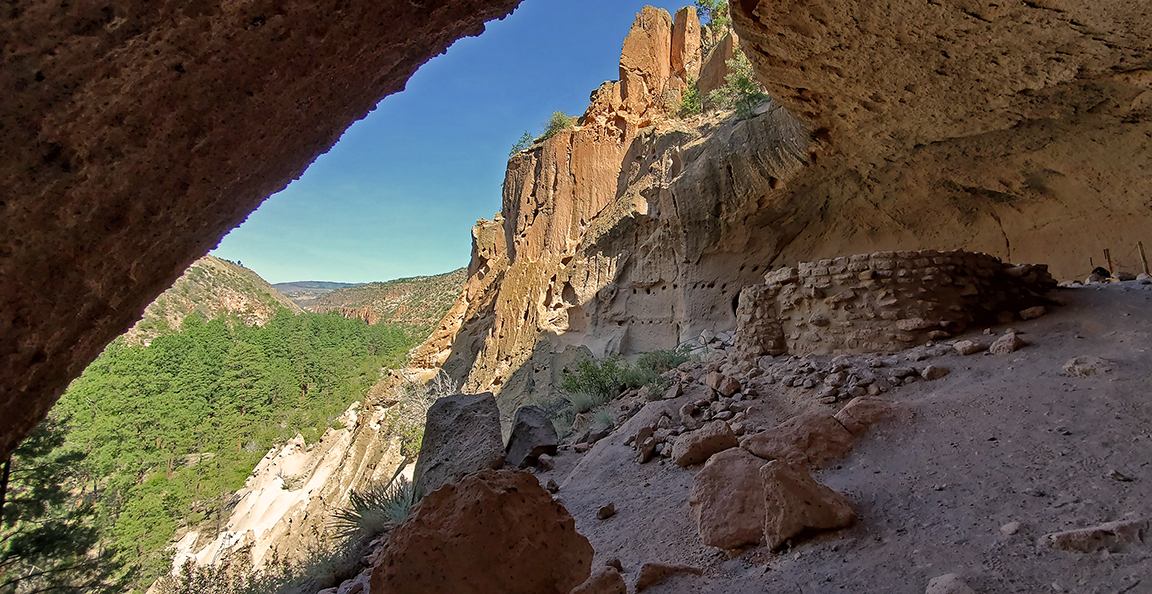 alcove house view 81620 11 crop a stone structure sits in an alcove with a view into a canyon and blue sky behind
