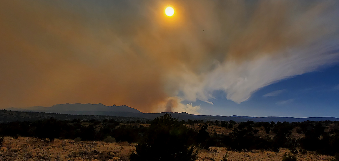 Smoke fills the air with a mountain and the sun obscured