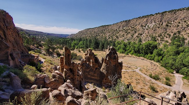 a view of a narrow canyon with a circular set of walls from an Ancestral Pueblo village