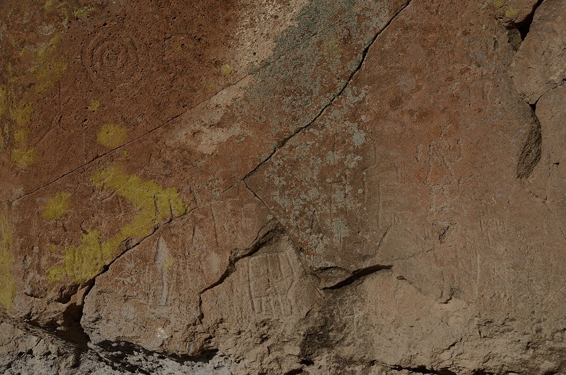 a stone wall with many carved images