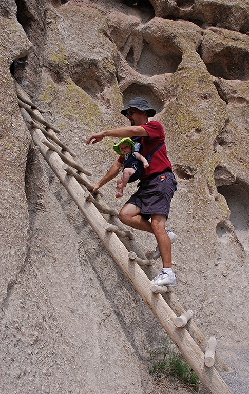 man with baby on ladder