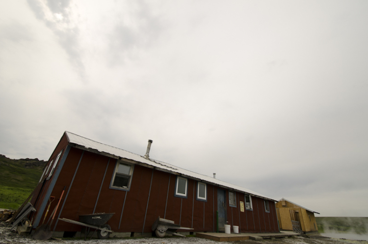 A wide-angle shot of the Serpentine Bunkhouse under dramatic cloudy skies